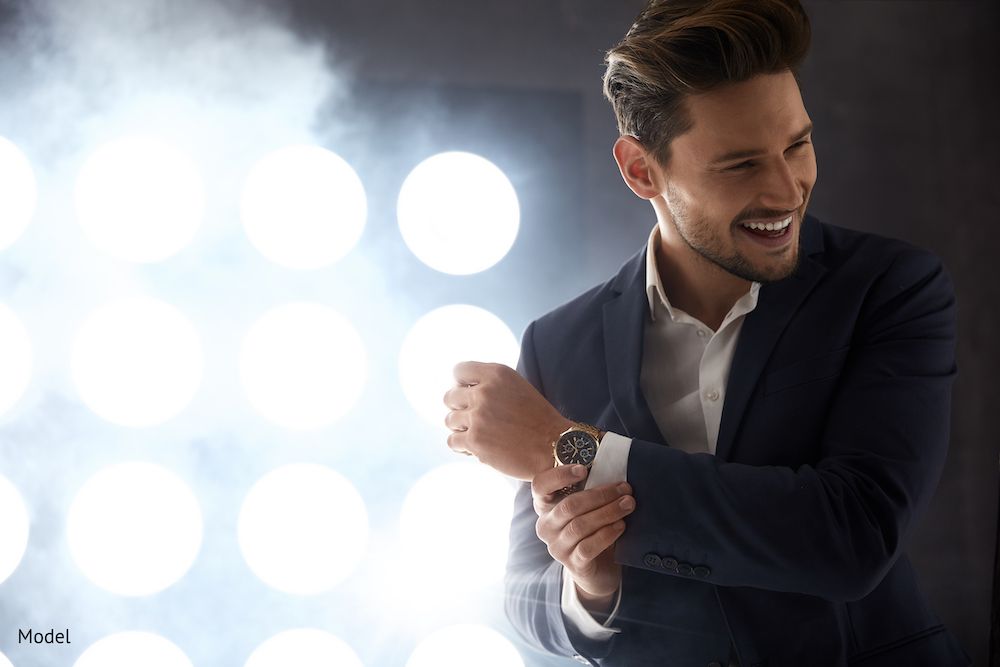 Attractive man in suit with white teeth in front of lights 