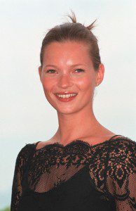 Model Kate Moss smiling in black lace dress and sleek updo