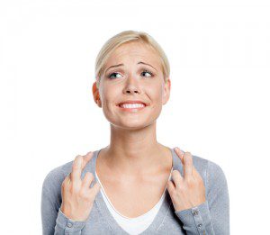 hopeful smiling woman crossing fingers