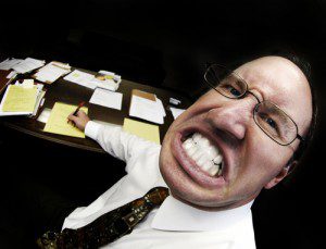 Mean looking man in business office gritting teeth