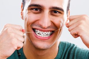 Man flossing with braces on