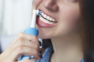 Close up of brushing teeth with electric toothbrush