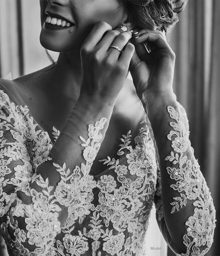 Woman smiling putting an earring on