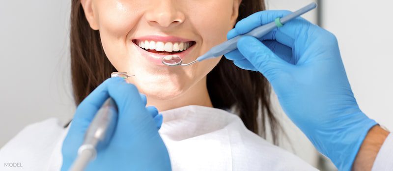 Cropped photo of smiling woman mouth under treatment at dental clinic
