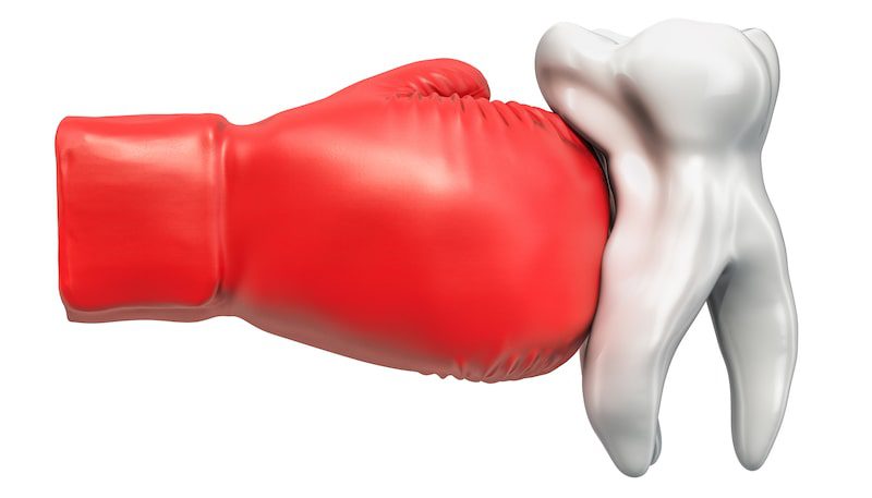  Illustration of a tooth being punched with a red boxing glove.