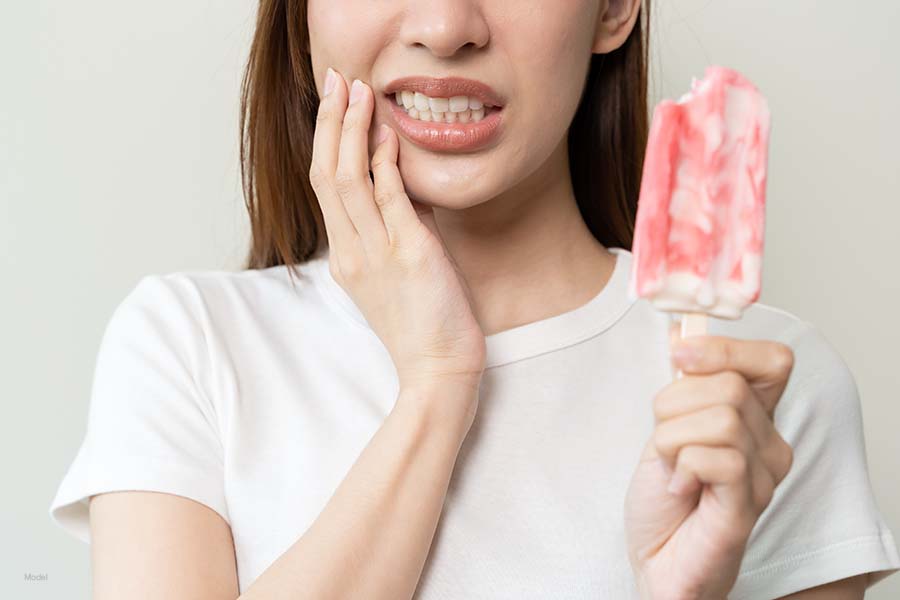 Woman exhibits tooth pain after biting a popsicle