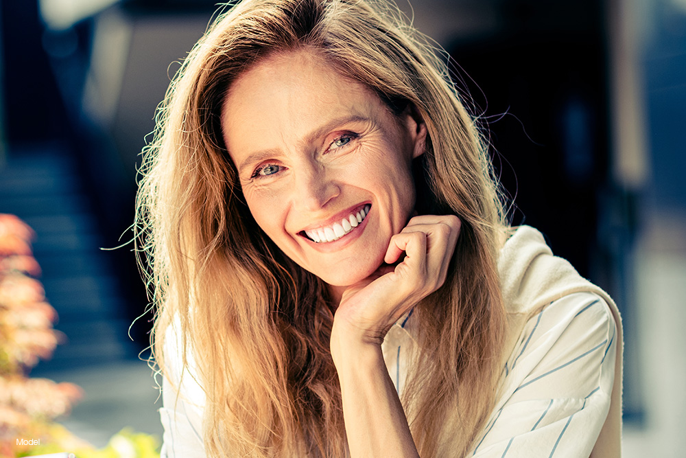 Mature woman with her hand on her chin smiling